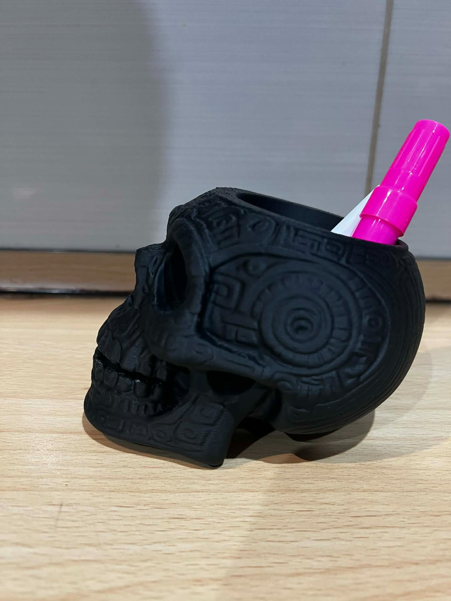 Díszes asztali tolltartó – Koponya design „FDM technológiával készült, matt fekete anyagból. Kiváló példa a 3D nyomtatás szabadságára: komplex formák és részletgazdag, textúrált felületek valósíthatóak meg.”